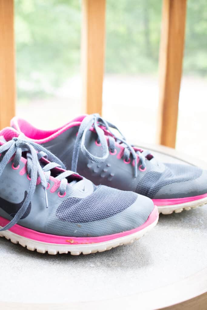 Mesh running shoes air drying on a porch.