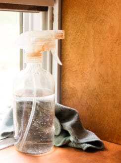 A mold killer for cleaning window sills sitting on a wooden window sill.