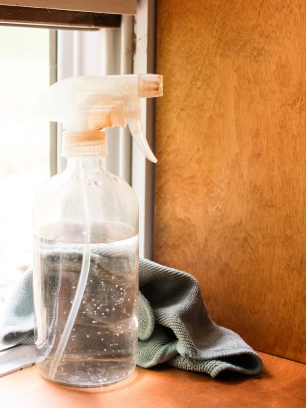 A mold killer for cleaning window sills sitting on a wooden window sill.
