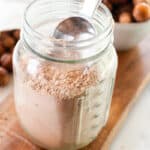 Soap nut laundry detergent in a mason jar for storage with a metal scoop.