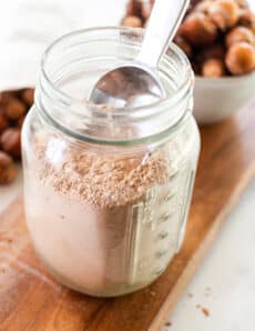 Soap nut laundry detergent in a mason jar for storage with a metal scoop.