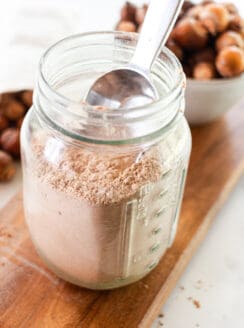 Soap nut laundry detergent in a mason jar for storage with a metal scoop.