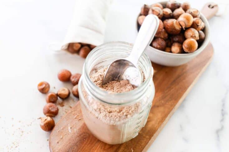 Soap nut laundry detergent in a glass storage container on a wooden shelf.
