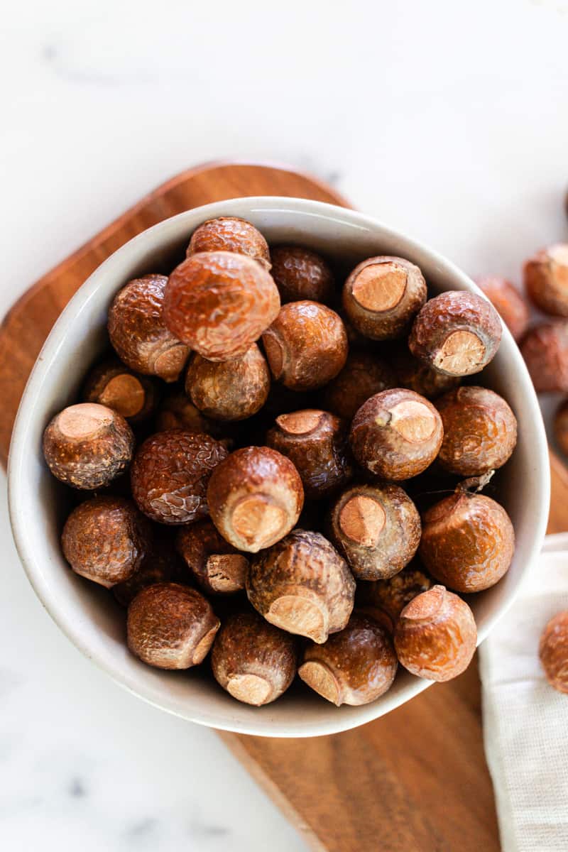 Soap nuts, stored in a bowl on white marble.