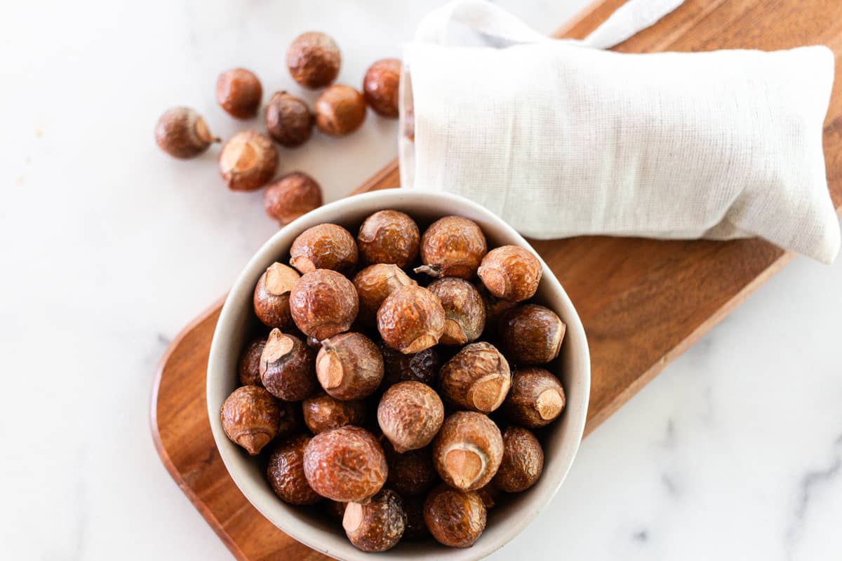 Soap nuts sitting on a wooden board.
