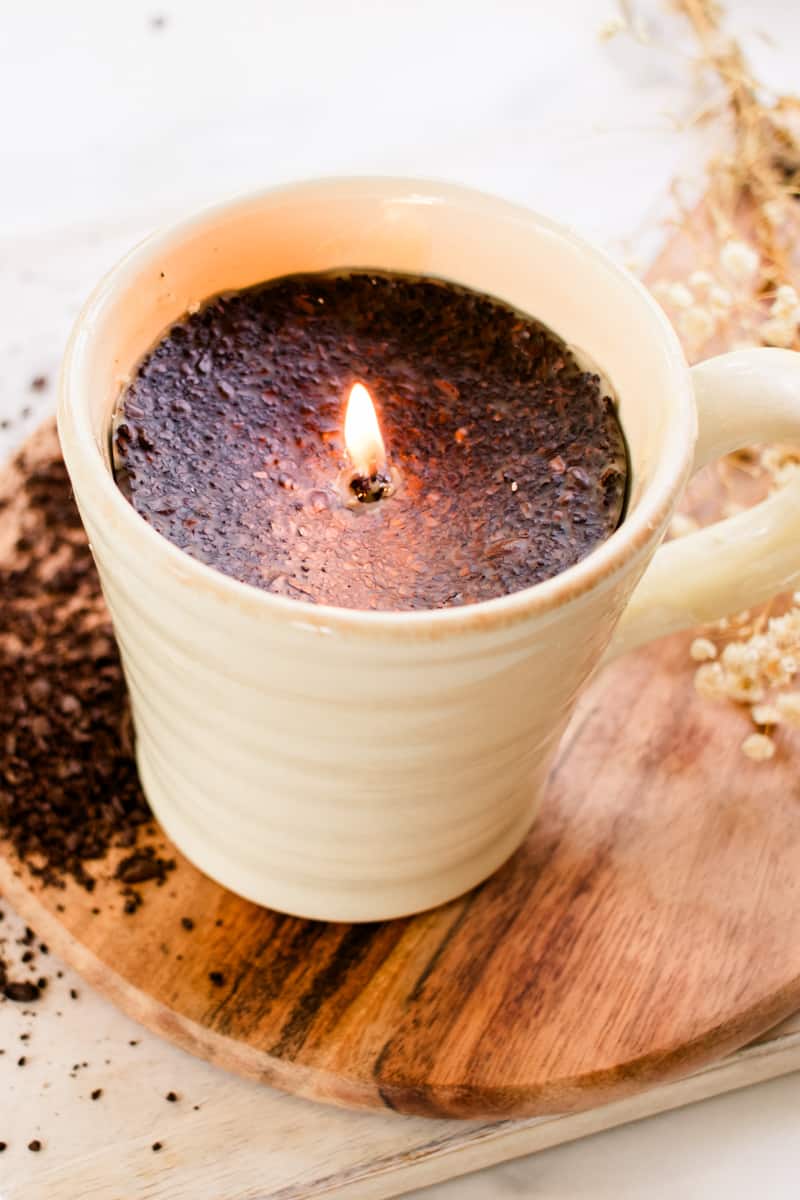 Lighting a DIY coffee candle for the first time after making it in a coffee mug.