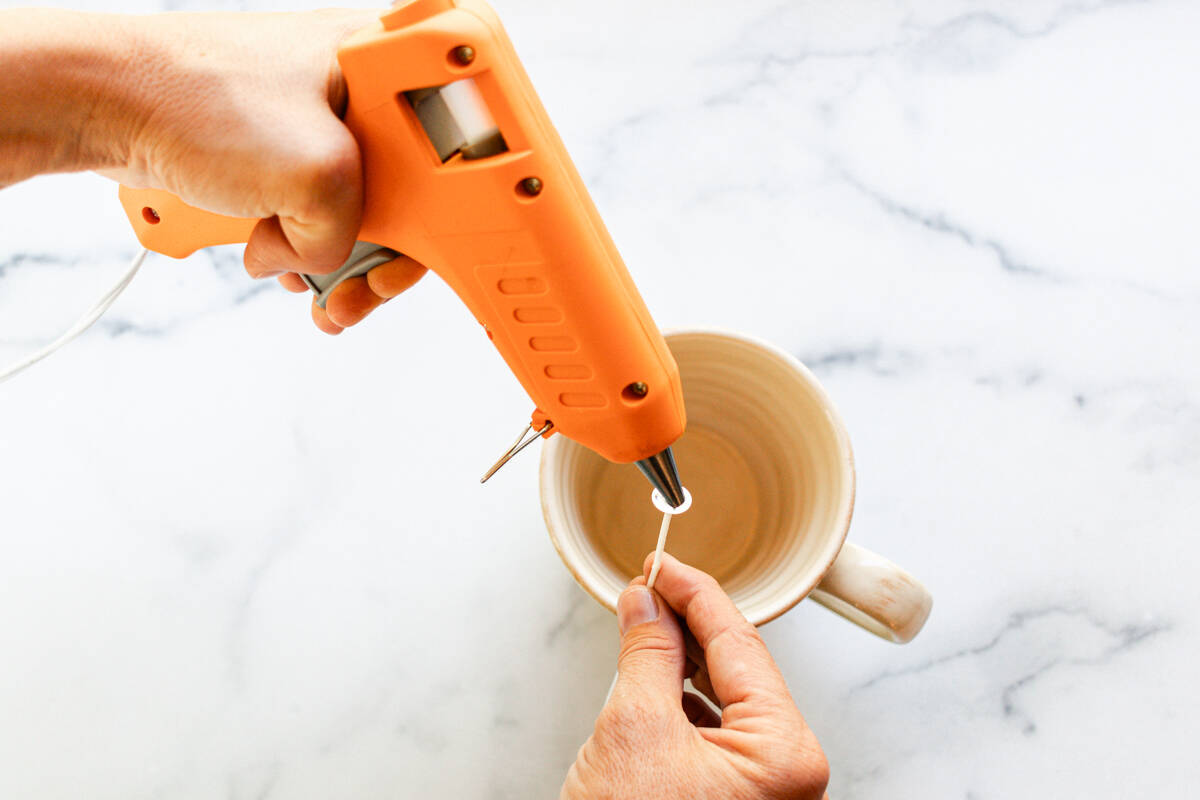 Glueing the wick into the mug.