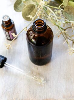 A DIY facial oil in an amber dropper bottle on a wooden table.