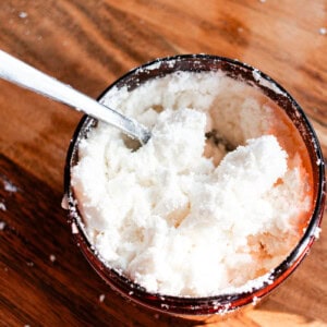 Stirring a coconut milk bath ingredients in a small bowl.