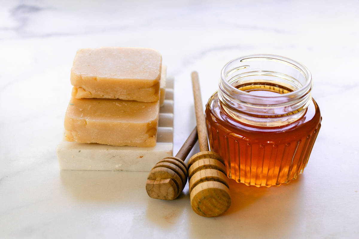 A small stack of soap bars made with honey on a soap rack.