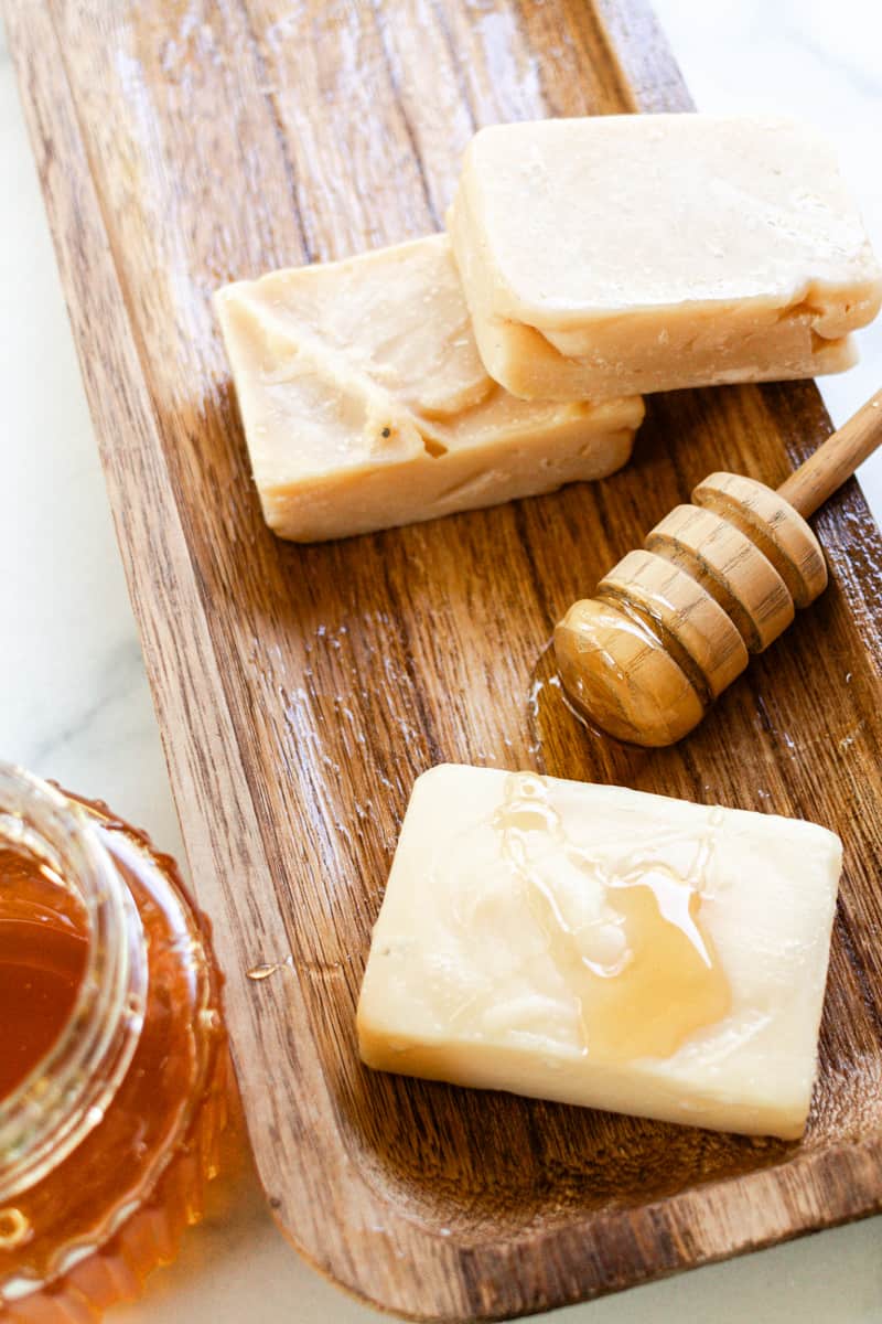 Several homemade honey soap bars with honey drizzled across the top. 