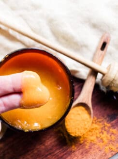 Dipping fingers into the sea moss face mask to apply to the skin.