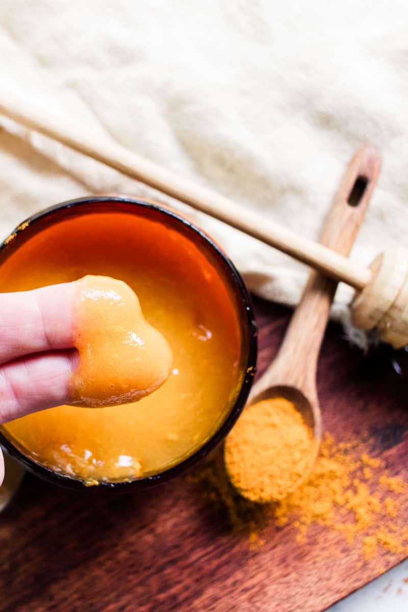 Dipping fingers into the sea moss face mask to apply to the skin.