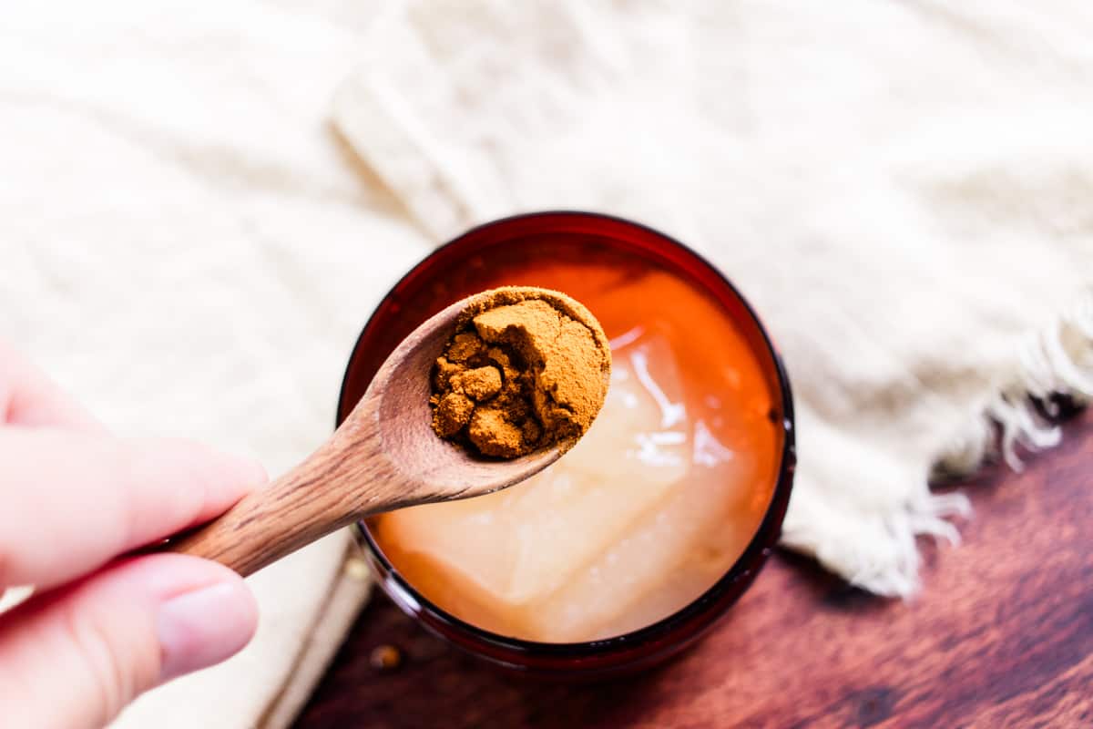 Adding turmeric to the container.