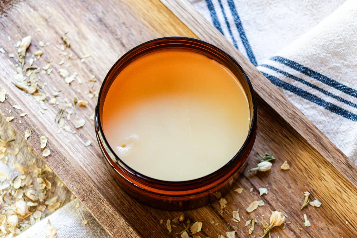 Homemade tallow balm cooling in a plastic container.