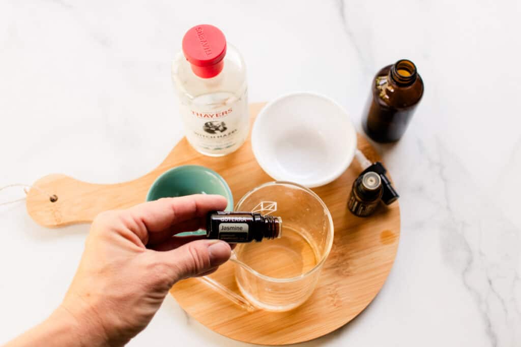 Adding the essential oils to the hair perfume. 