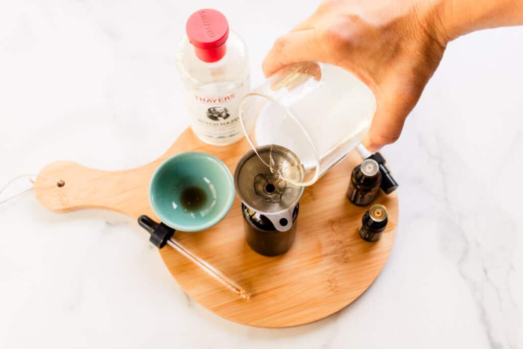 Pouring the hair perfume into the spray bottle.