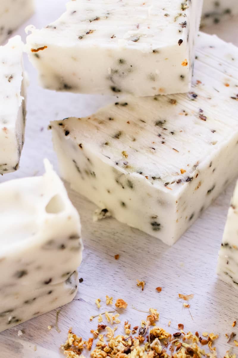 Herb soap bars stacked on a white vanity.