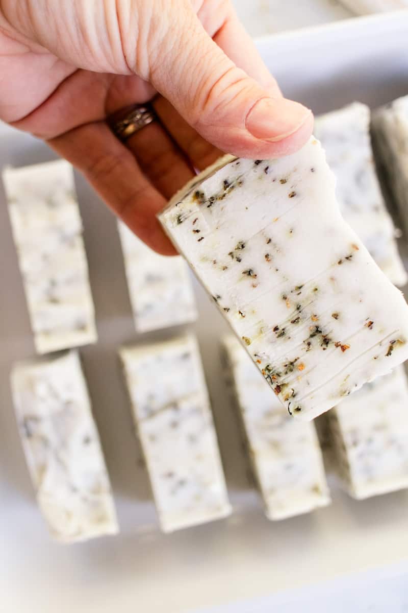 Holding a newly cured herbal soap bar up for a close up shot.