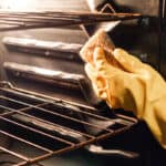 Scrubbing an oven after the grease has been loosened up with steam.