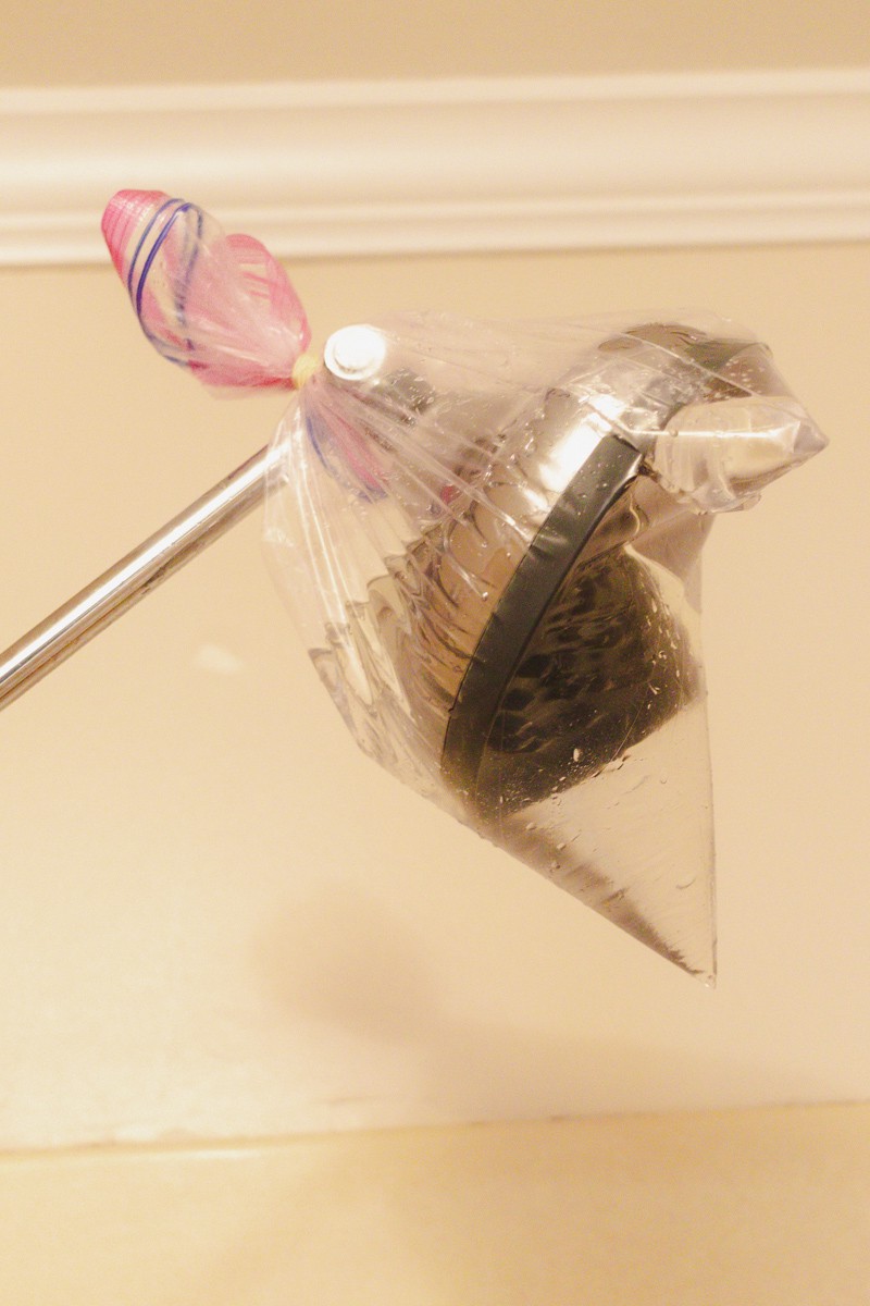 Tying a ziplock bag to the shower head with a rubber band to clean the spray nozzles.