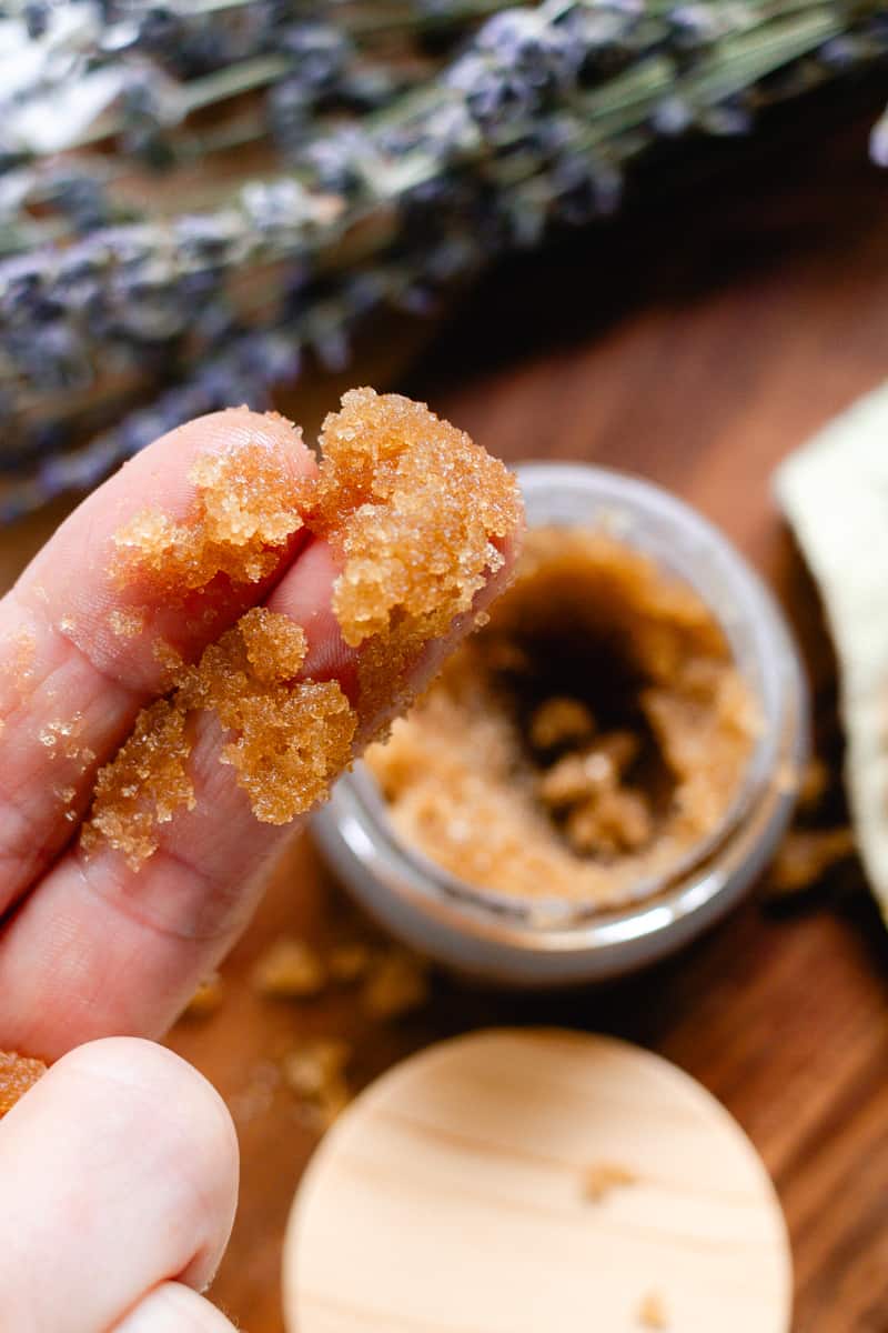 Using 2 fingers to scoop up the underarm sugar scrub and apply it to the armpits.