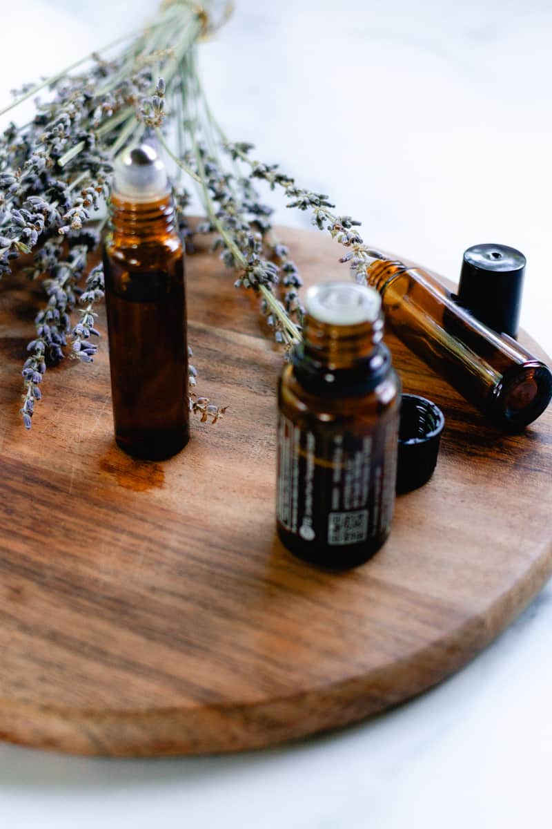 Essential oil bottles surrounding a roller bottle ready to make a lip oil.