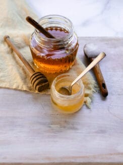 A homemade lip mask in a small jar with a spoon for stirring.