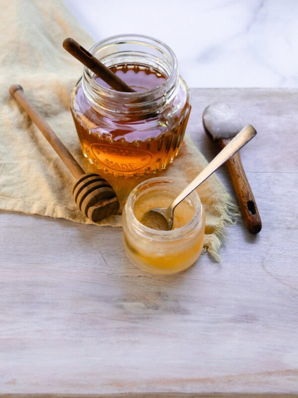 A homemade lip mask in a small jar with a spoon for stirring.