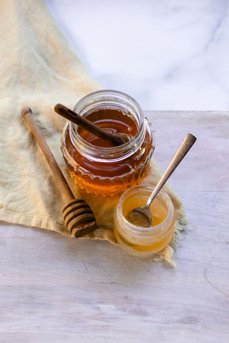 My DIY hydrating lip mask made with honey and coconut oil on a wooden table. 