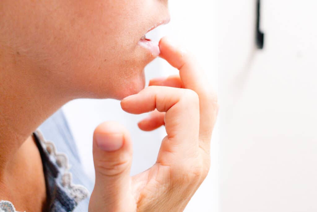 Applying the yogurt lip mask to my lips using my fingertips.