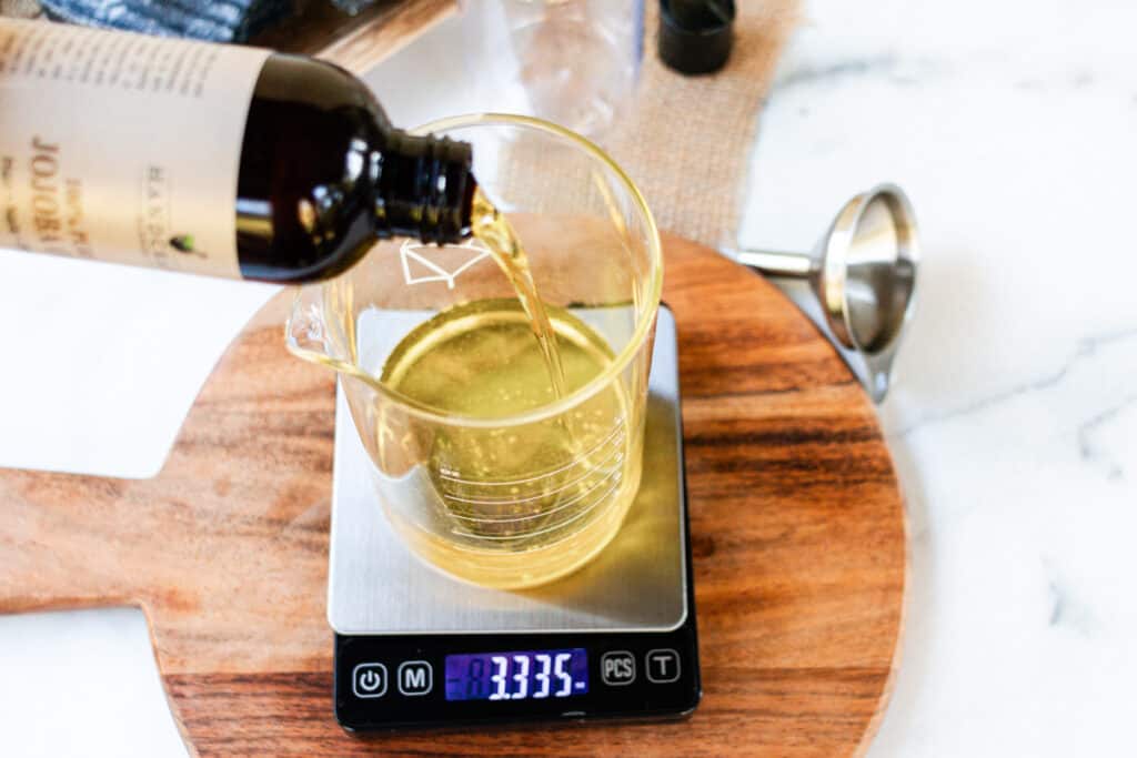 Measuring jojoba oil with a digital scale.
