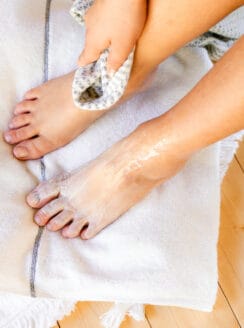 Wiping the foot mask off with a clean towel.