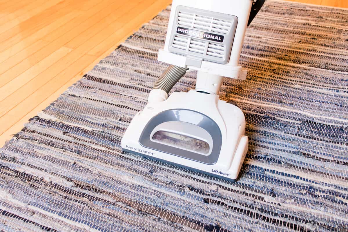 Vacuuming the braided rug in the direction of the braids to prevent damage.