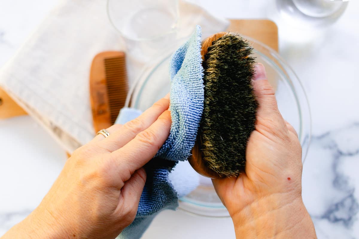 Wiping the boars bristle beard brush dry with a microfiber towel.