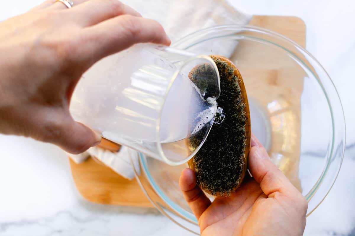 Pouring soapy water onto the dirty beard brush.