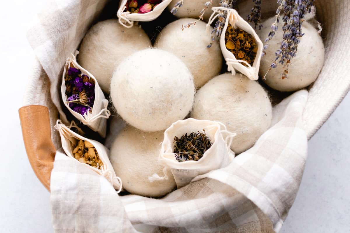 Wool dryer balls scented with dried herbs in a nice storage basket.