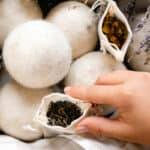 Placing a sachet with dried herbs for wool dryer balls into a basket to help create scent.