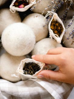 Placing a sachet with dried herbs for wool dryer balls into a basket to help create scent.