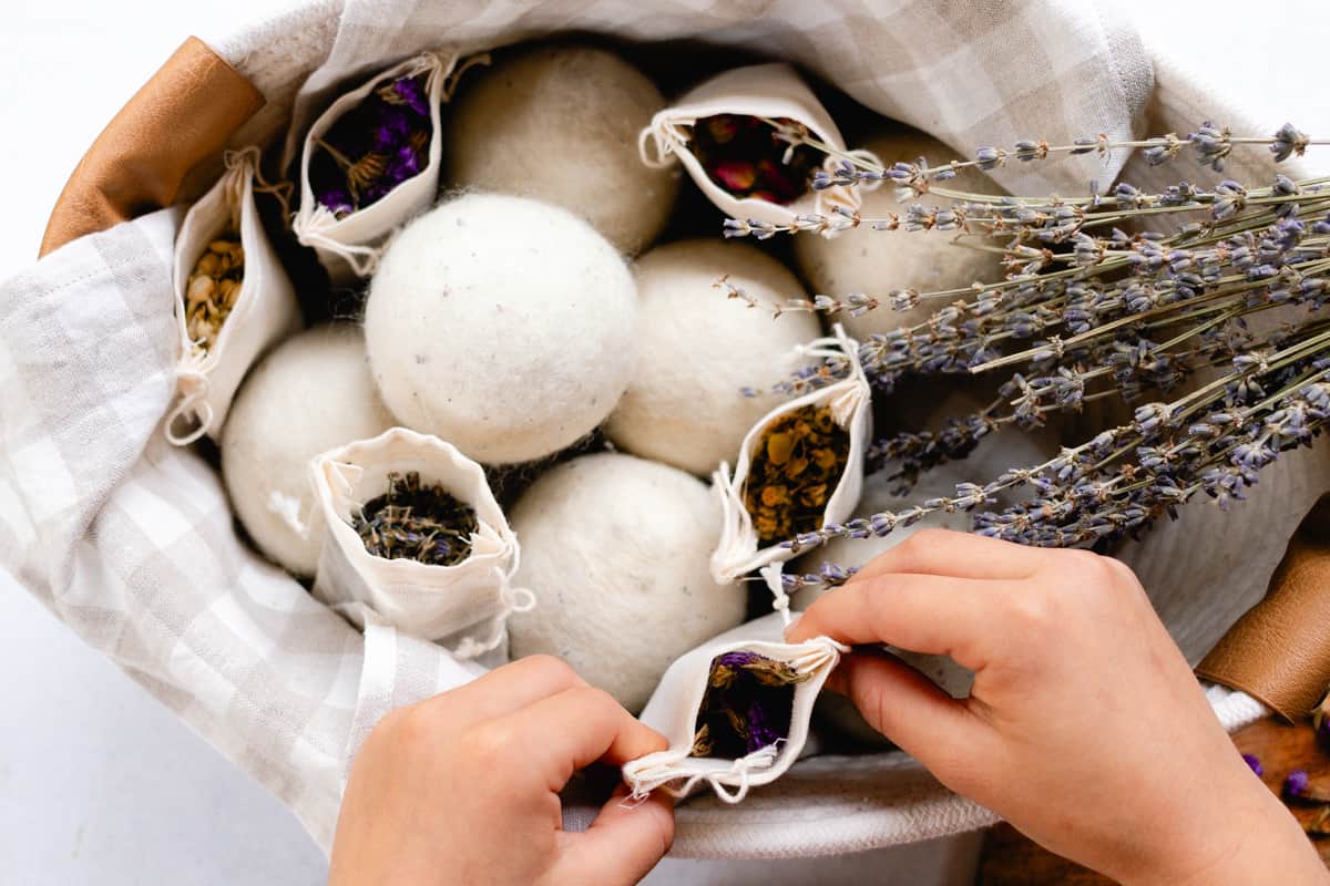 Placing the muslin bag into the basket with the dryer balls.