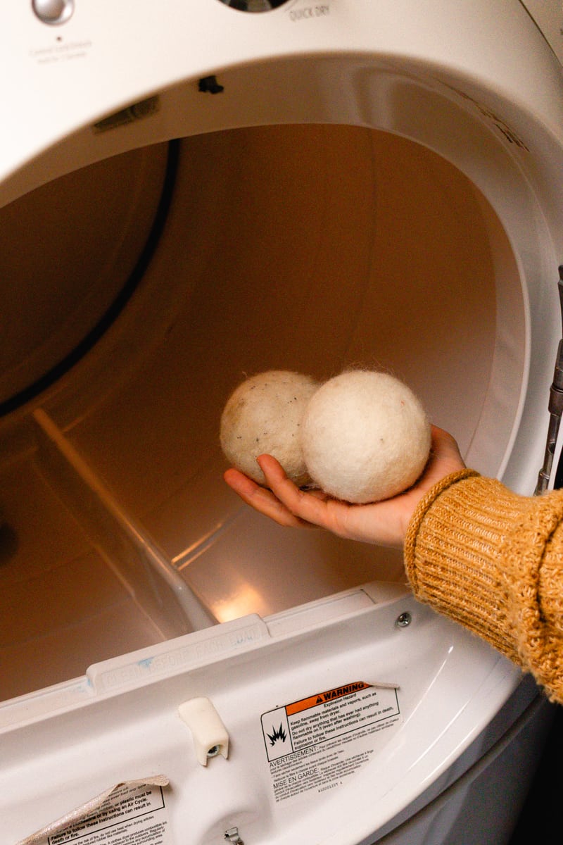 Placing the scented dryer balls into the dryer.