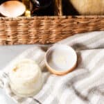 A beard balm on a white and grey tea towel.