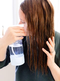 Spraying coconut water on my hair after shampooing.