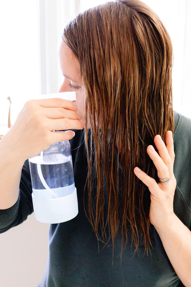 Spraying coconut water for the hair into my clean strands before conditioning.