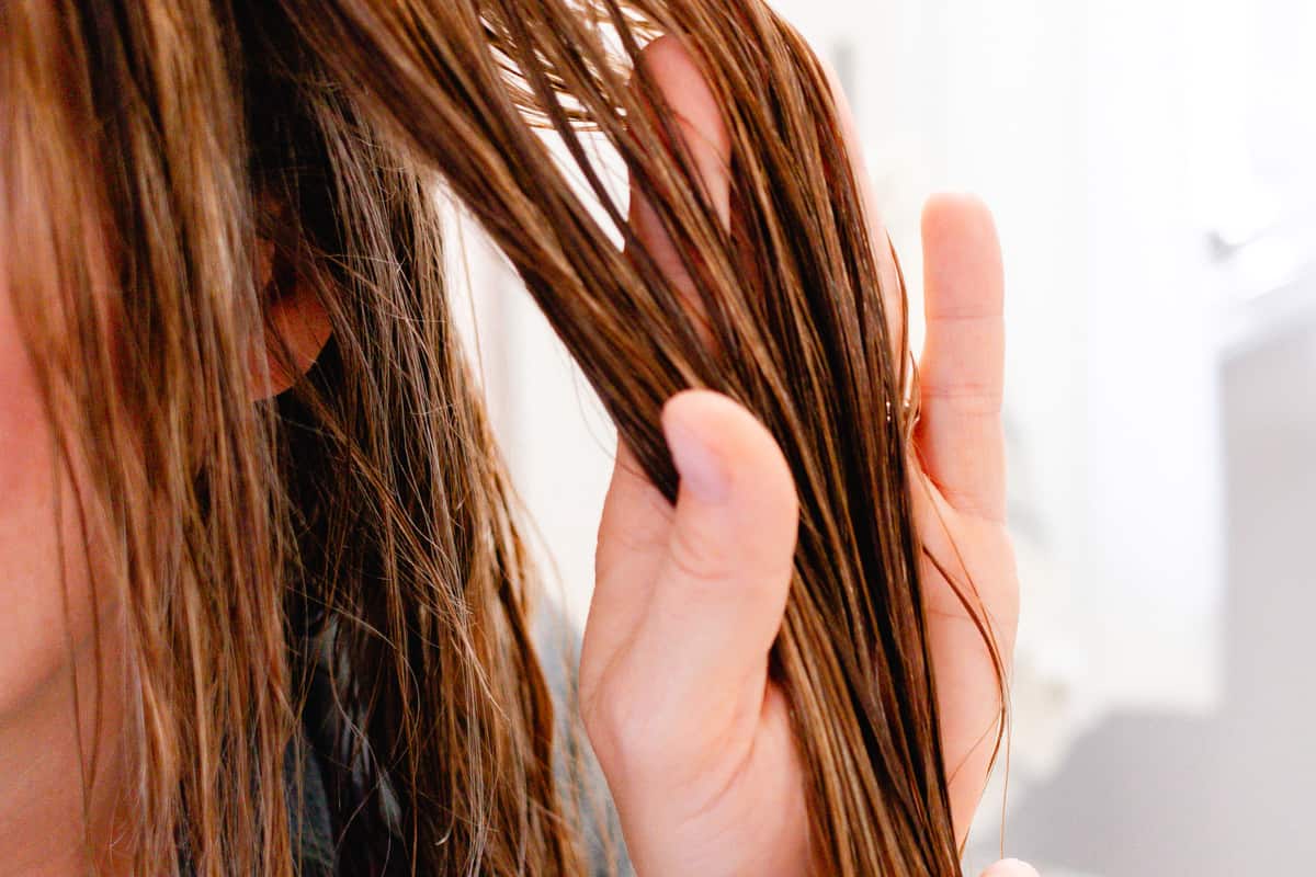 Holding out my clean hair to apply coconut water to hydrate it.