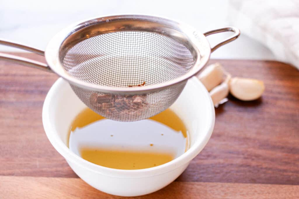 Straining the garlic from the oil.