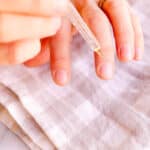Applying a nail growth serum to the fingernails.