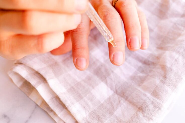 Applying a nail growth serum to the fingernails.