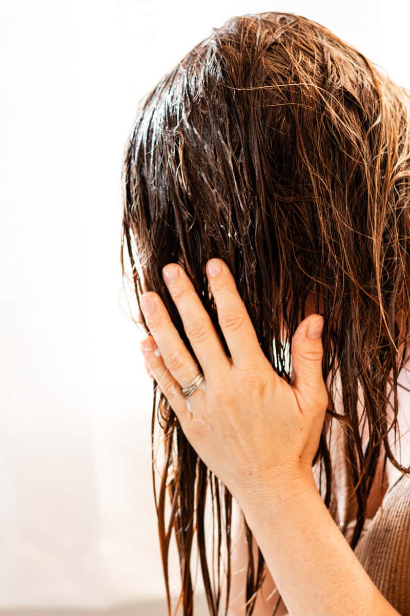 Working the conditioner with the epsom salts for hair into the strands.