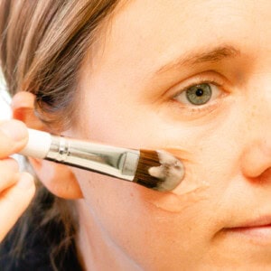 Applying my homemade liquid foundation to my cheeks.
